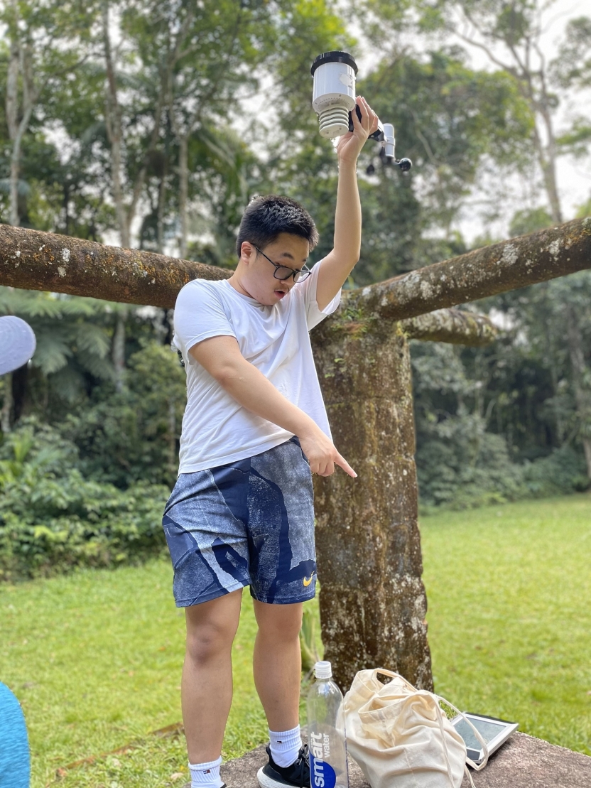 A student holding up measuring equipment