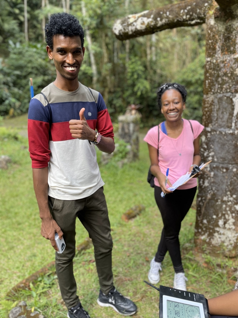 Students smiling and giving thumbs up to someone with a measurement device in the foreground