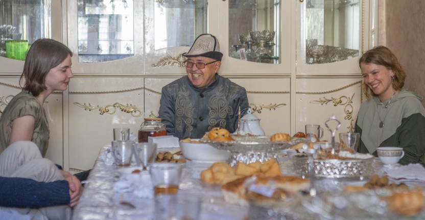 Students smiling at a dining table