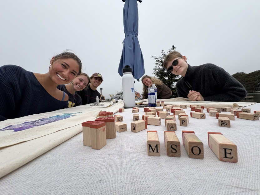 Students smile behind blocks arranged to spell "MSOE"