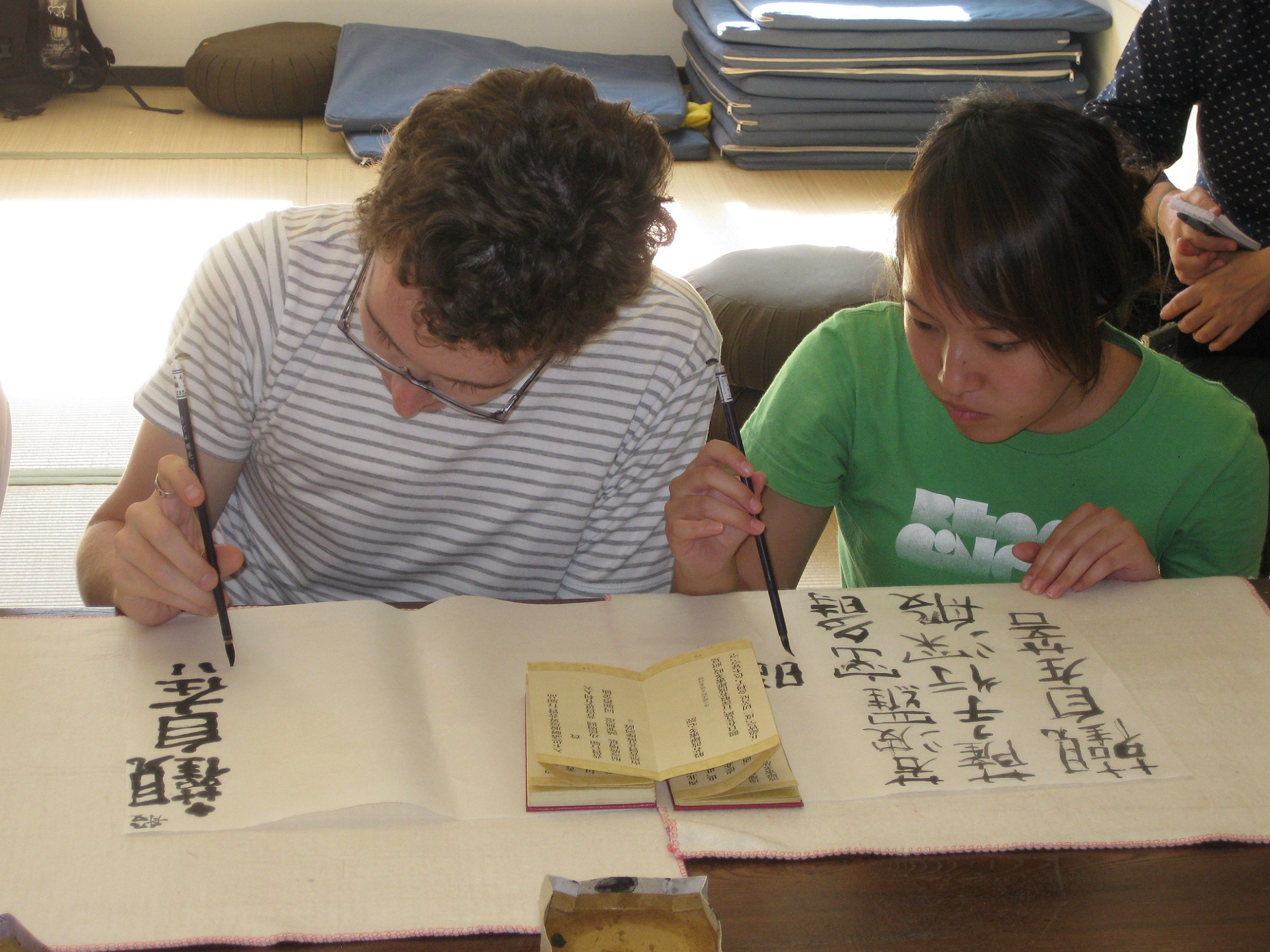 Students write Chinese characters with brushes and ink