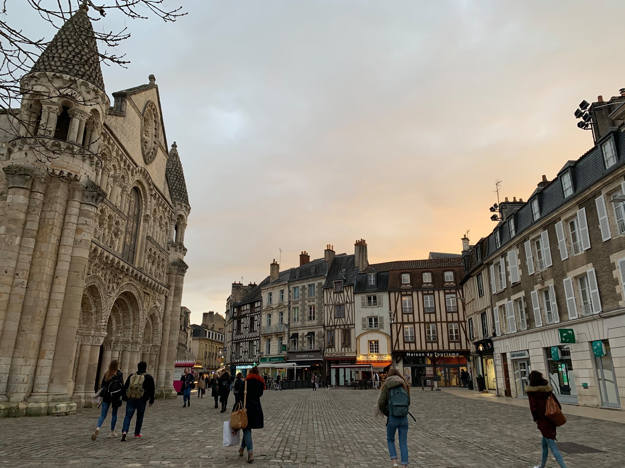People walking through a medieval town at dusk