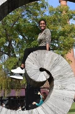 A student sits on a spiral sculpture