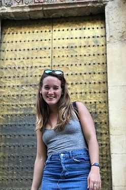 A student standing in front of a golden door