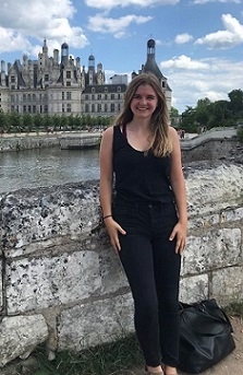 A student stands in front of a castle