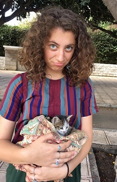 A student holds a kitten in a blanket
