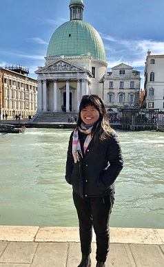 A student stands in front of a canal