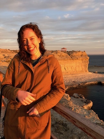 A study abroad student at the Middlebury School in Argentina stands on the coast