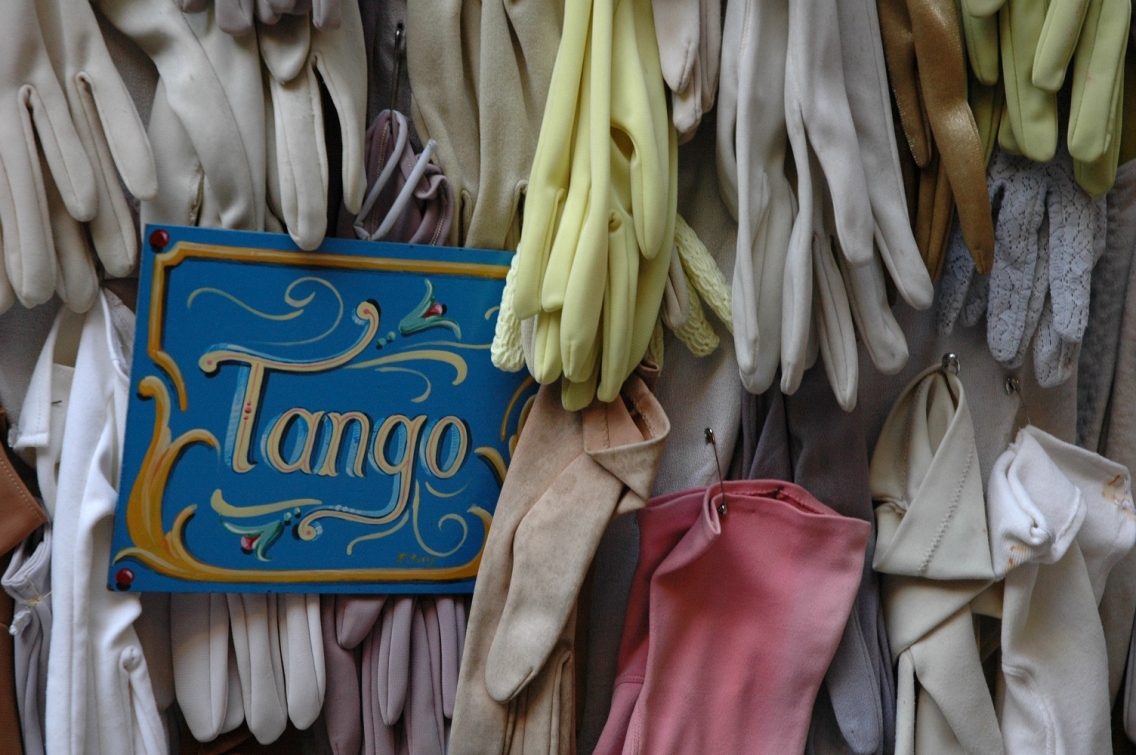 gloves hanging up around a sign that says "Tango"