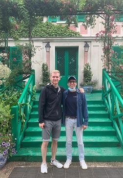 A student and his friend in front of a building