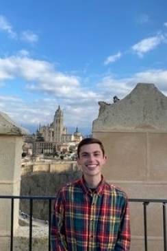 Student smiling with a large building in the background