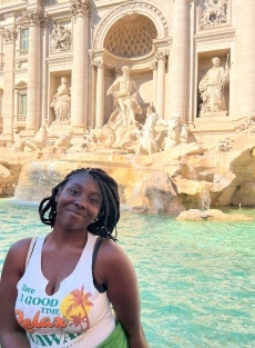 A student smiling in front of an Italian fountain