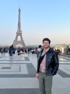 Student smiling in front of the Eiffel Tower
