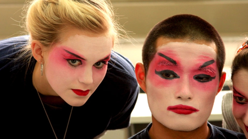 Two students painting their faces in tratidional dance make up