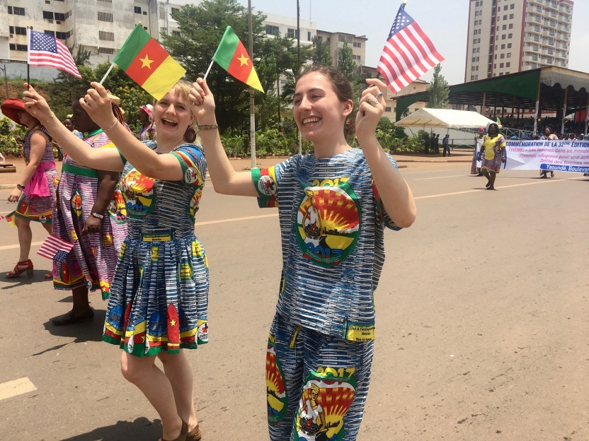 Students marching with American and Cameroonian flags
