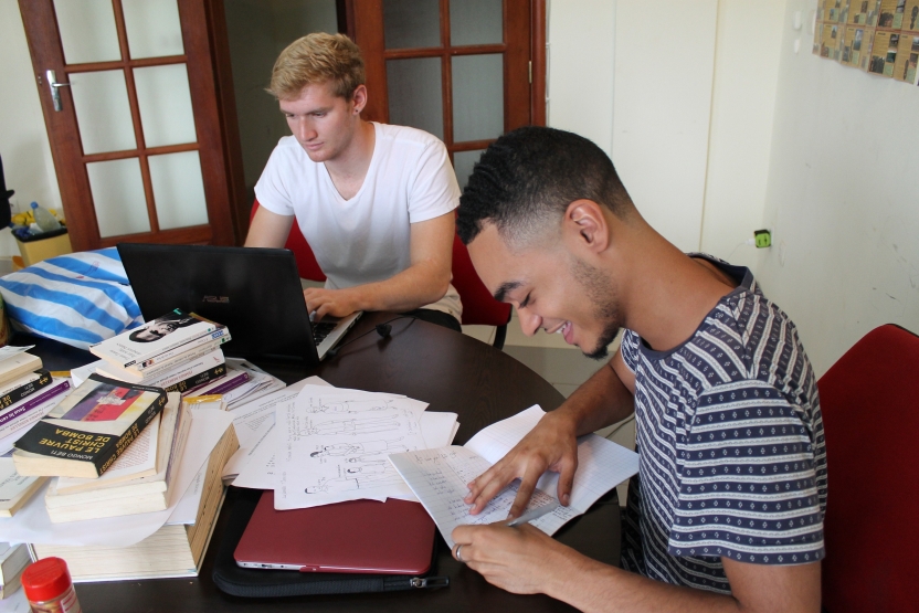 Two students write at a table in the Middlebury Center