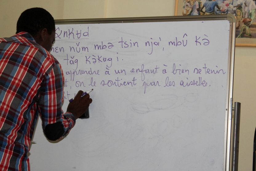 A professor writes in Medumba on a white board