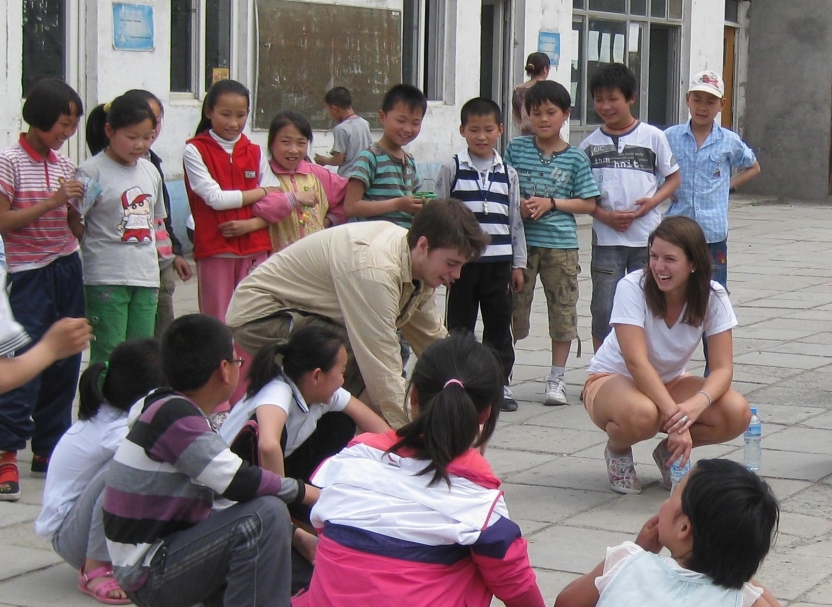 Students playing with a group of children