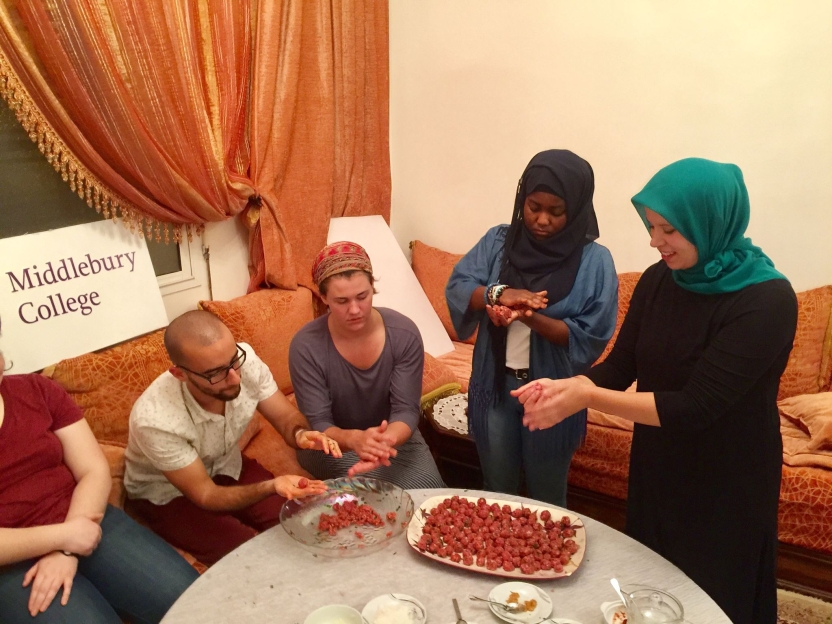 Students and a host mother form meatballs together