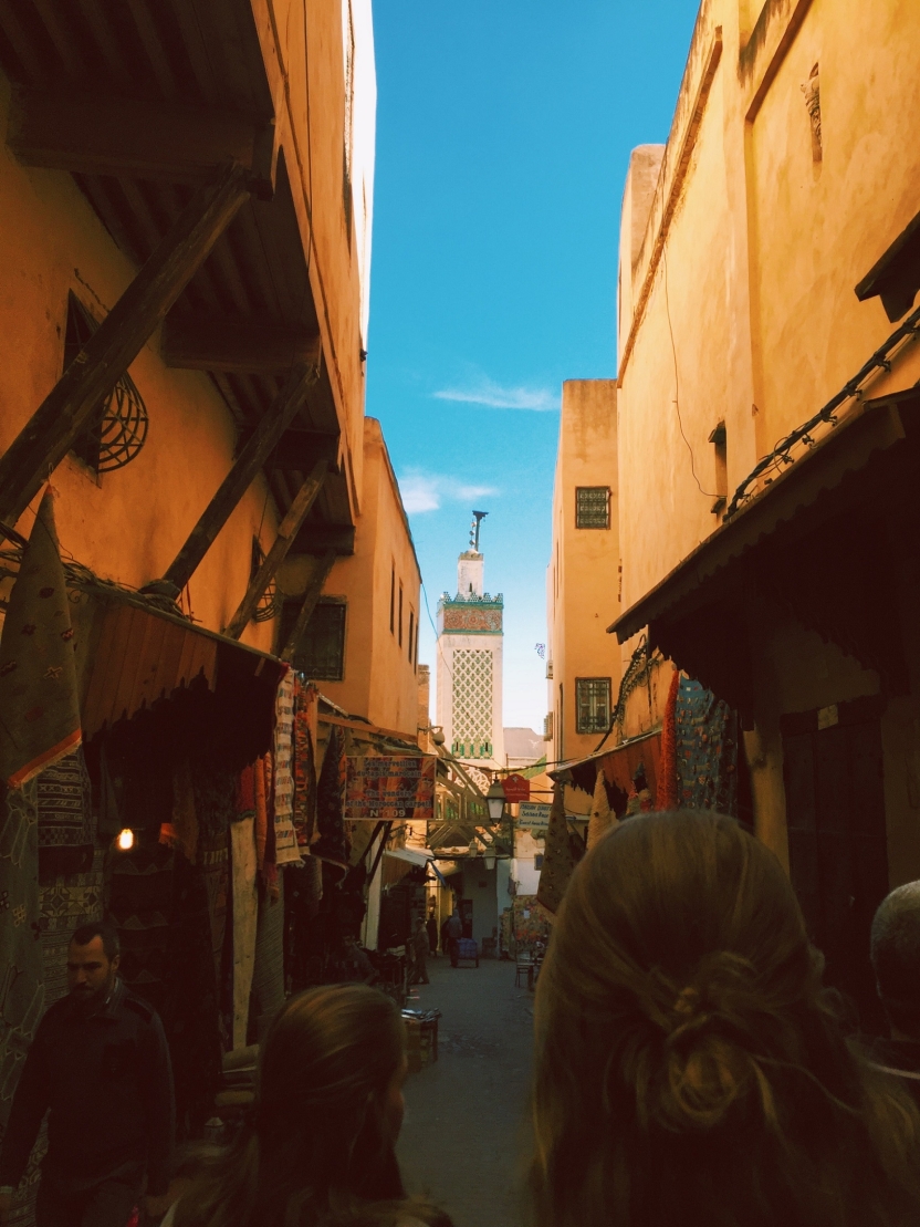 Students walk along a narrow street in an old city area