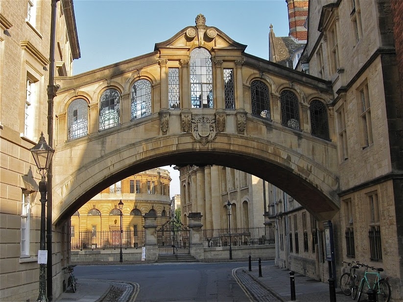 An enclosed bridge connects two buildings, crossing over a street