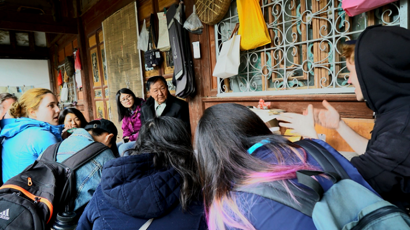 Students in a group, conversing with an older man