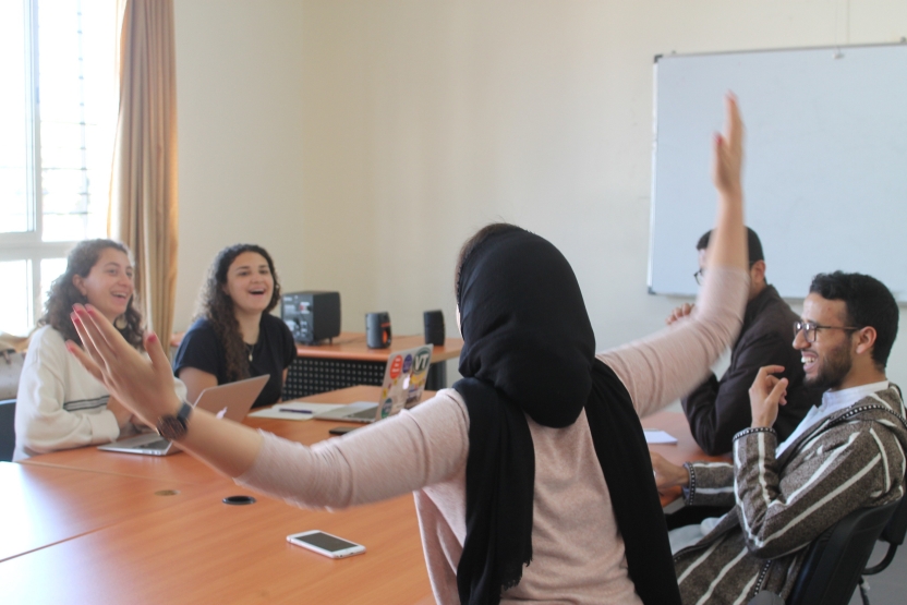 An instructor gestures and students laugh