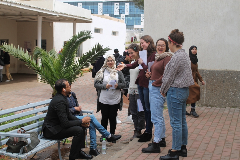 Students speak in a group on a university campus