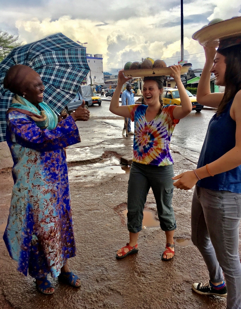 Students laugh with a woman on the street