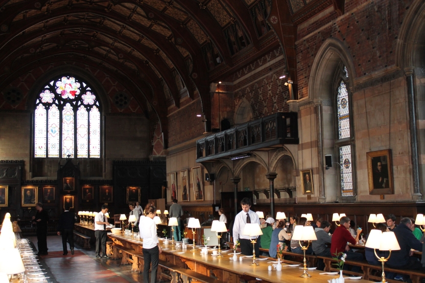 Long tables in a dining hall with students eating at one of them