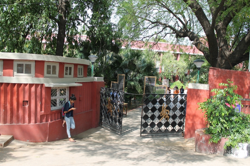 A student waits outside the gates of the campus