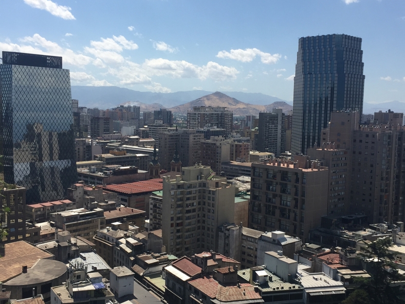 A view of skyscrapers with a mountain range behind them