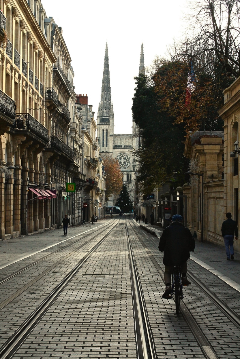 A man bicycles down the cobblestone streets of Bordeaux