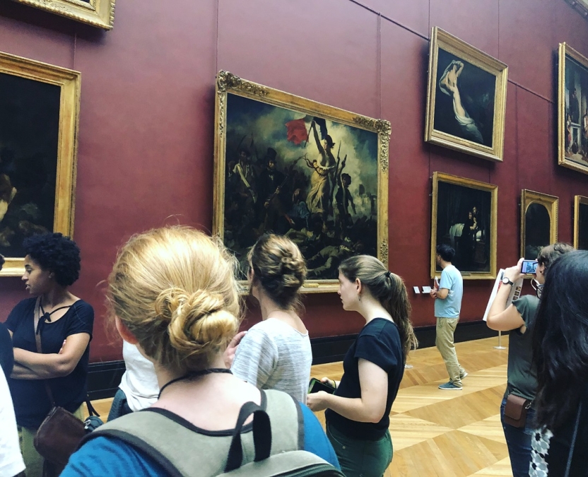 Students look at artwork in a museum
