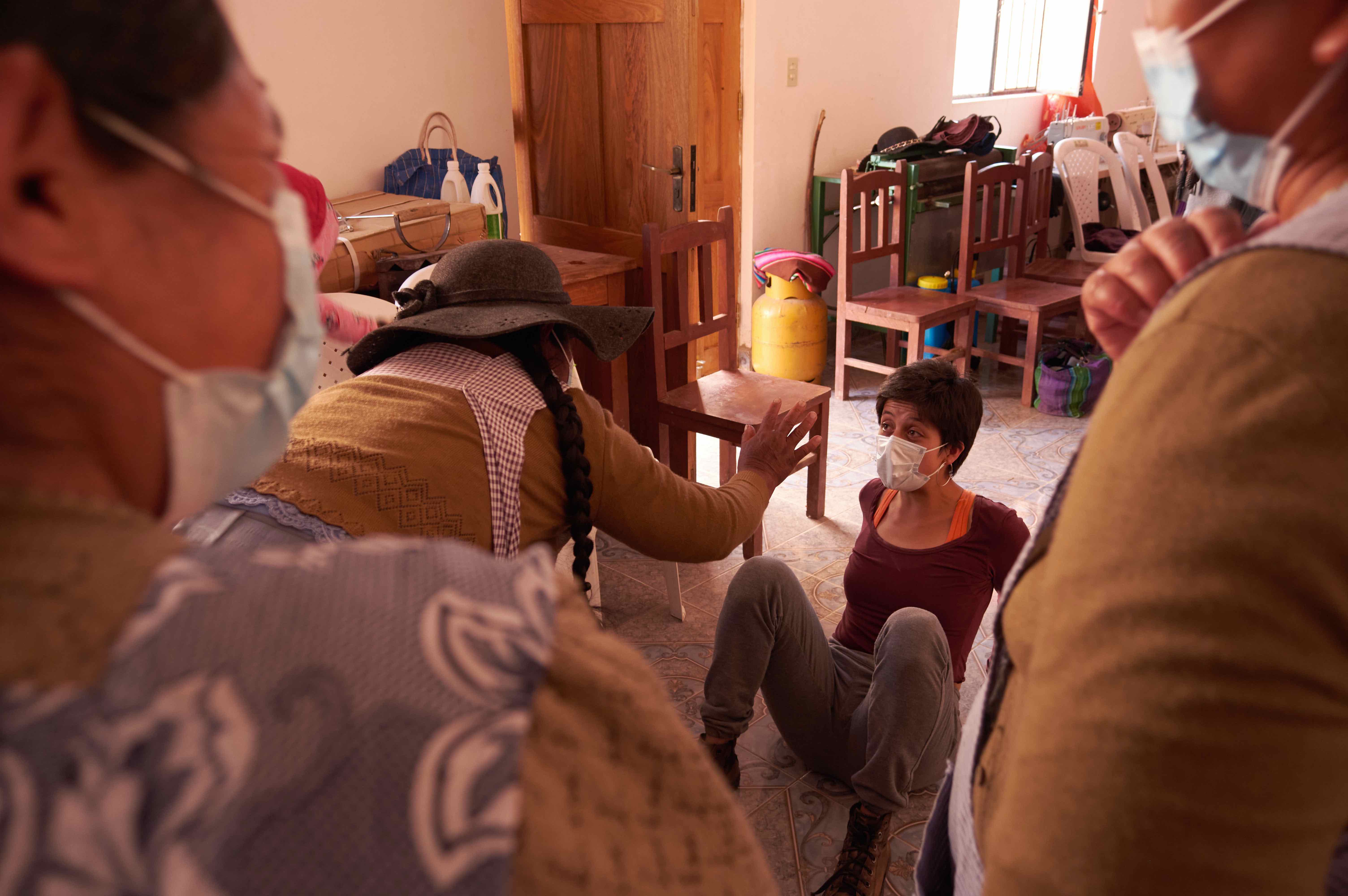 A group of women wearing masks gather indoors to carry out a physical activity