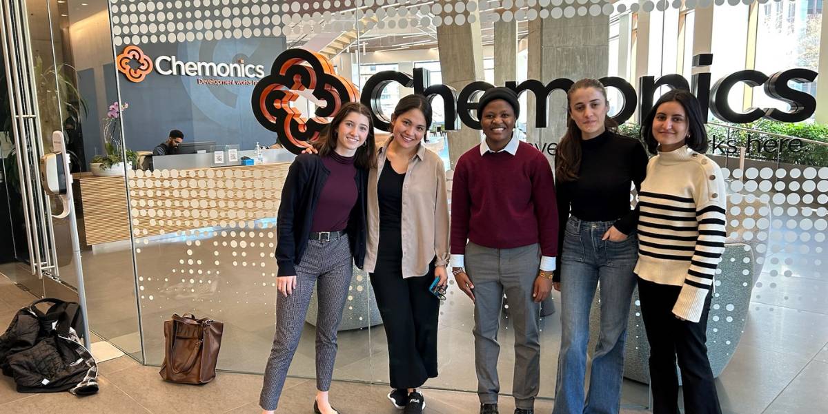 5 students pose under the Chemonics sign.