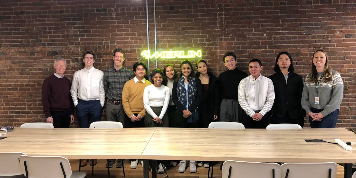 A group of students and staff pose in the conference room.