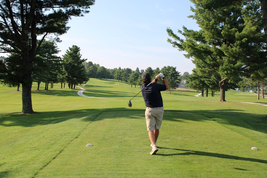 Colleagues standing together playing golf