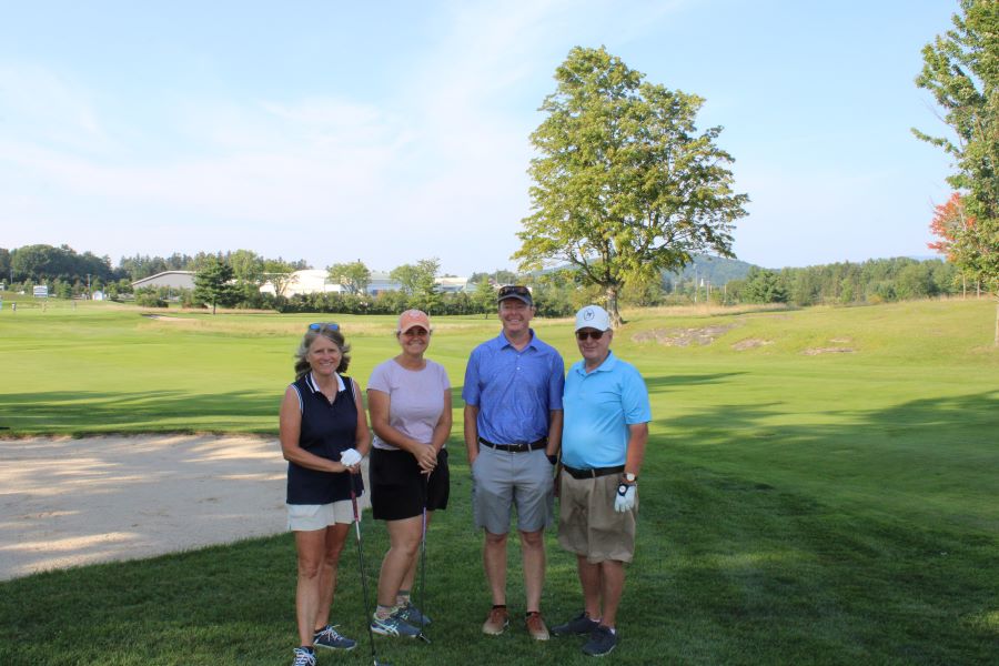 Colleagues standing together playing golf