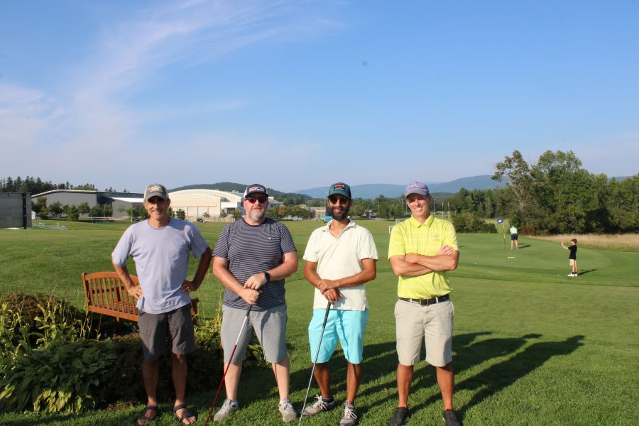 Colleagues standing together playing golf