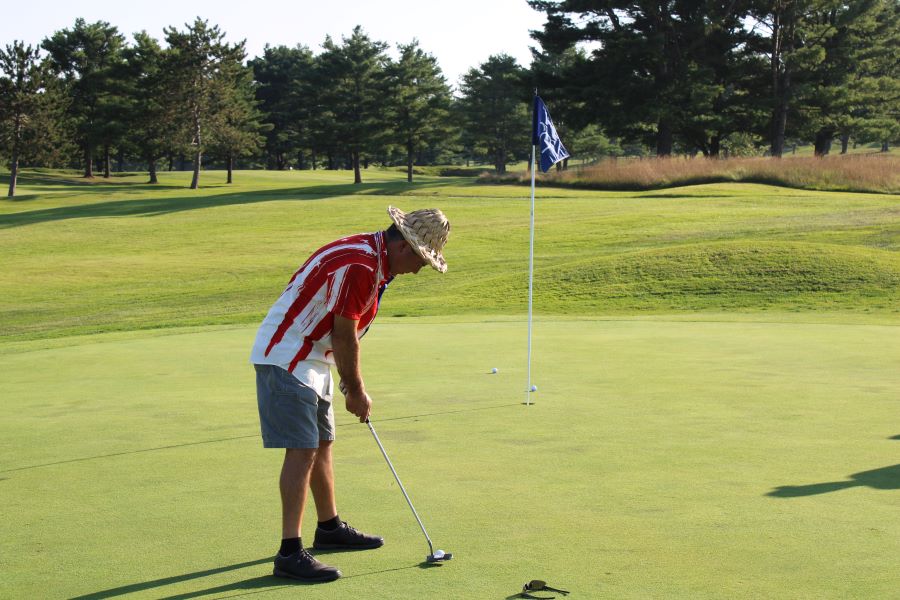 Colleagues standing together playing golf