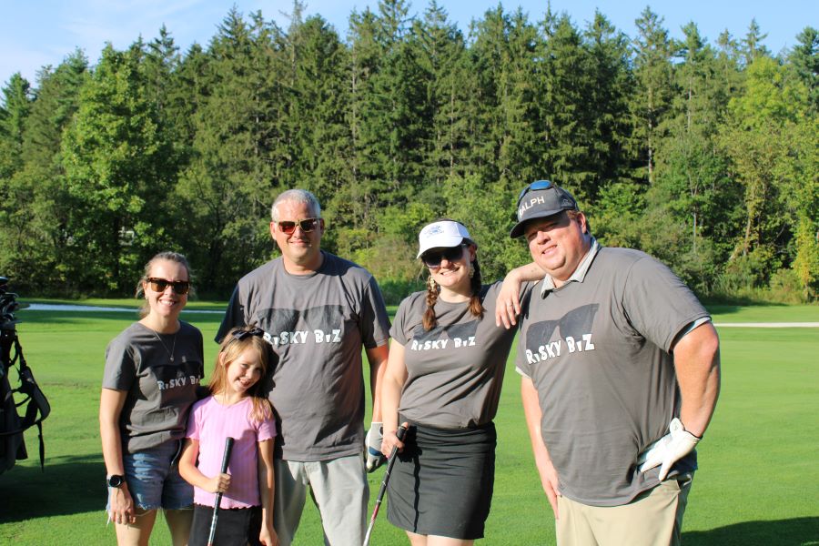 Colleagues standing together playing golf