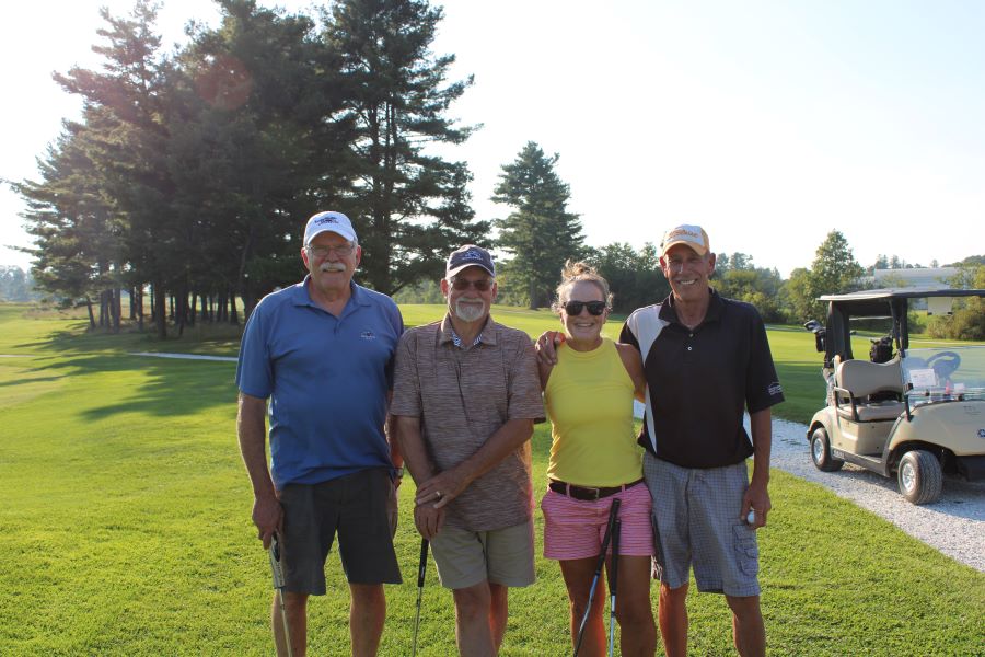 Colleagues standing together playing golf