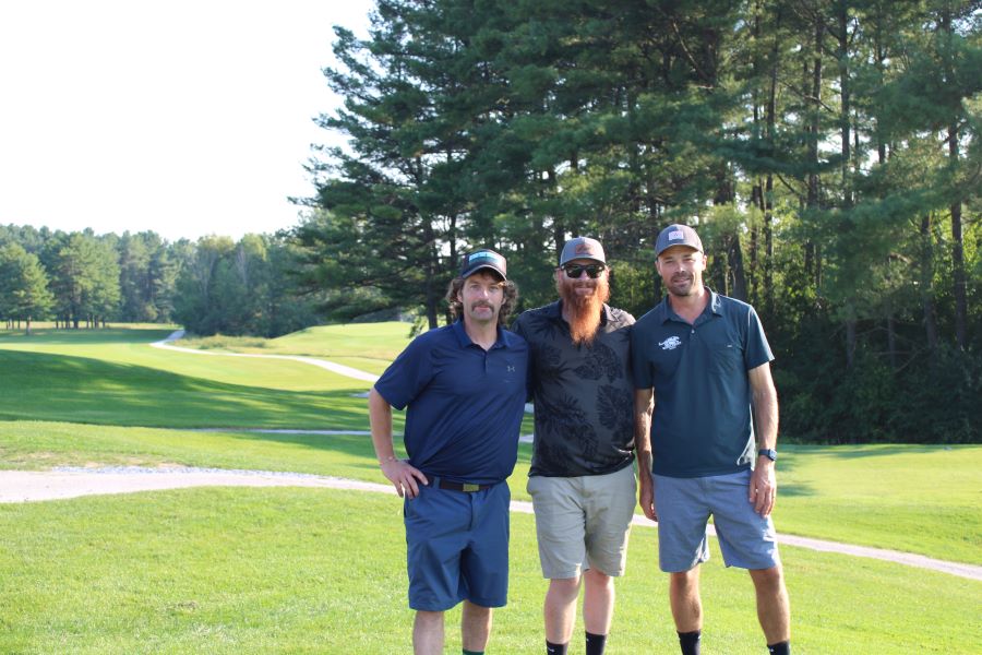 Colleagues standing together playing golf