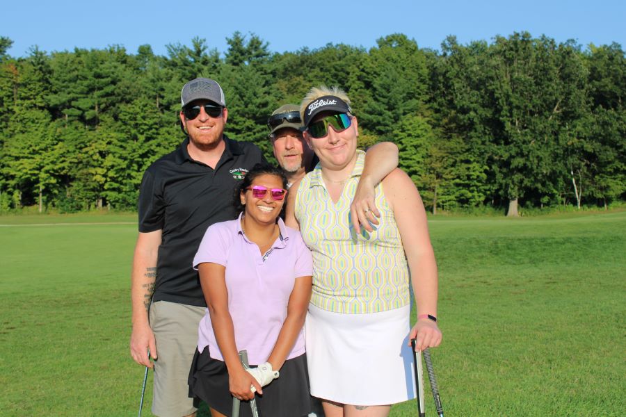 Colleagues standing together playing golf
