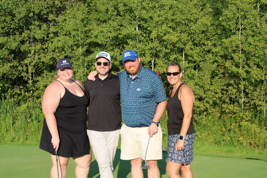 Colleagues standing together playing golf
