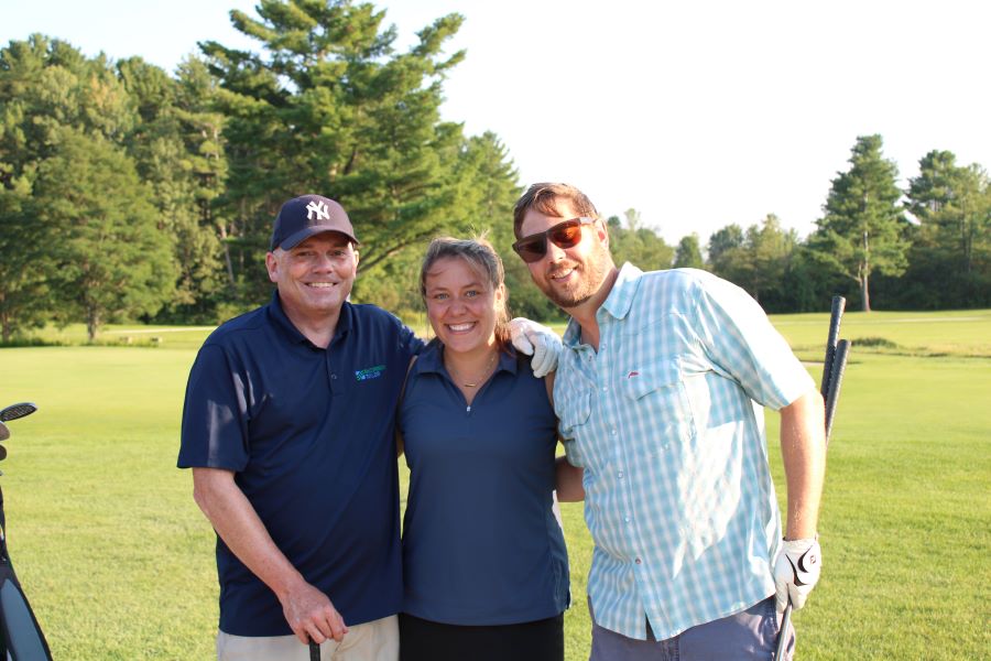 Colleagues standing together playing golf