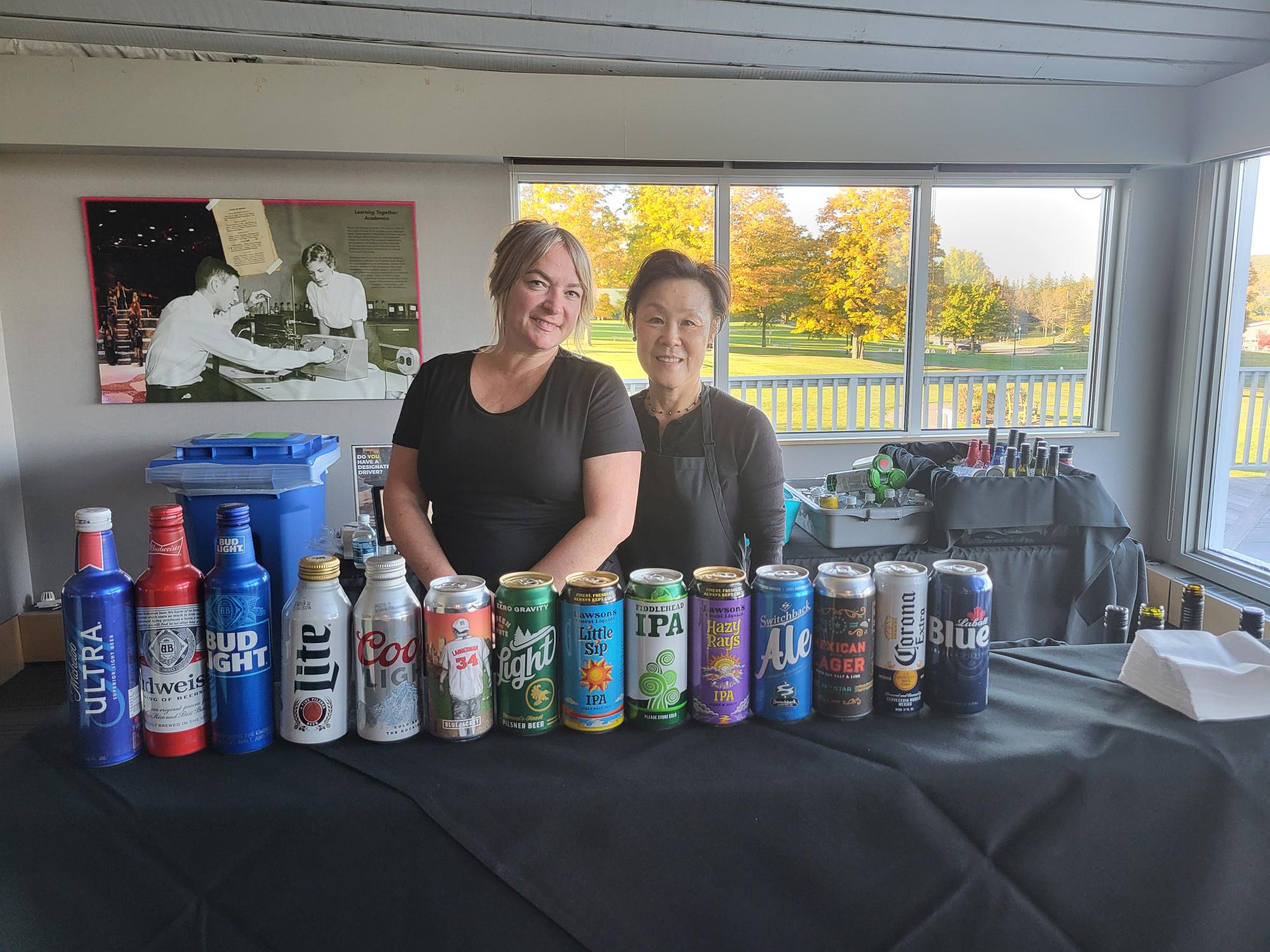 2 bartenders standing behind bar smiling before event