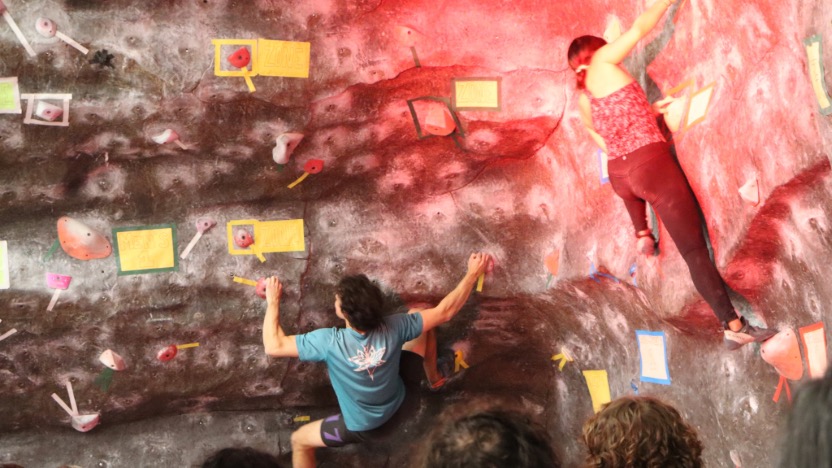 Two climbers climbing back to back.