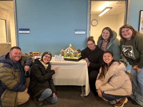 staff from res life standing next to gingerbread creation